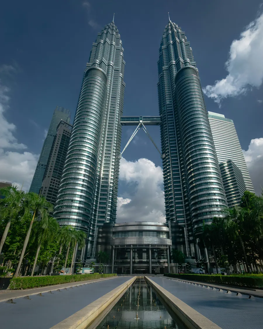 Menara Berkembar Petronas dilihat dari hujung kolam pantulan panjang yang dikelilingi pokok palma