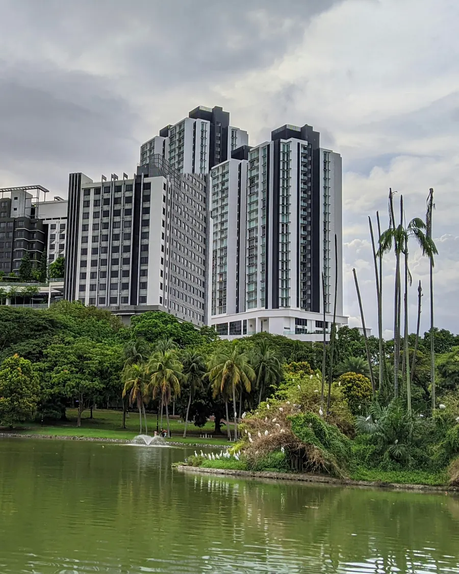 Menara kondominium di atas tasik dan taman tropika di pinggir Mont Kiara