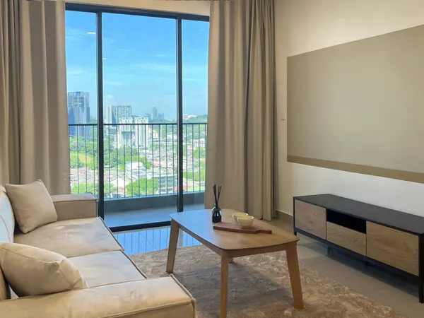 Ruang tamu dengan sofa linen dan tingkap menghadap pokok dan menara